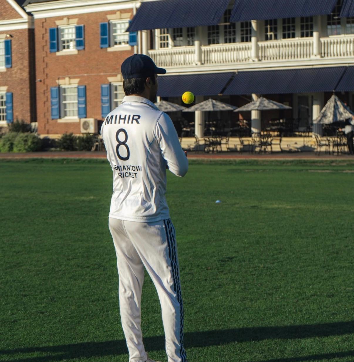 A GCC player practicing with a tennis ball in front of the clubhouse