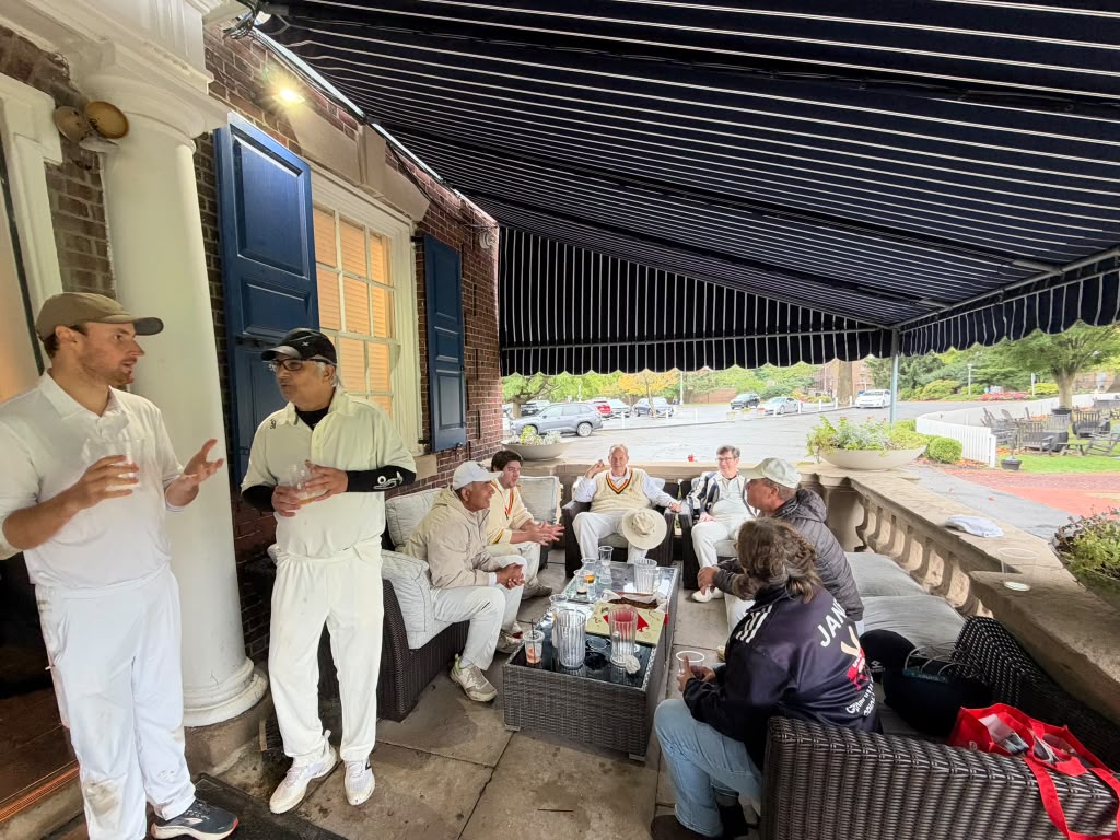 GCC and PCC players talking on the clubhouse porch between showers